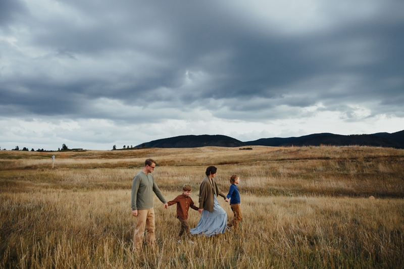 Family Photographer, Family of four walks through a dry field together