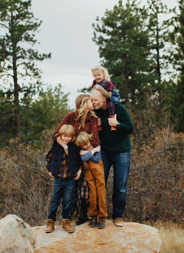 Family Photographer, a mother and father stand with their three children in the forest