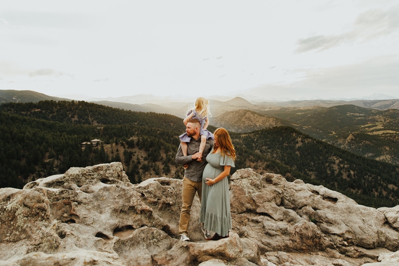 Family Photographer, A mother and father stand on a cliffside overlooking the wilderness with their daughter
